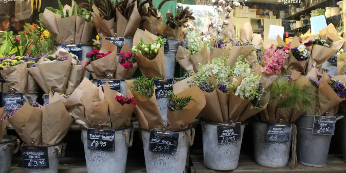 Rows of zinc buckets filled with paper-wrapped bunches of flowers, each with a chalkboard price tag